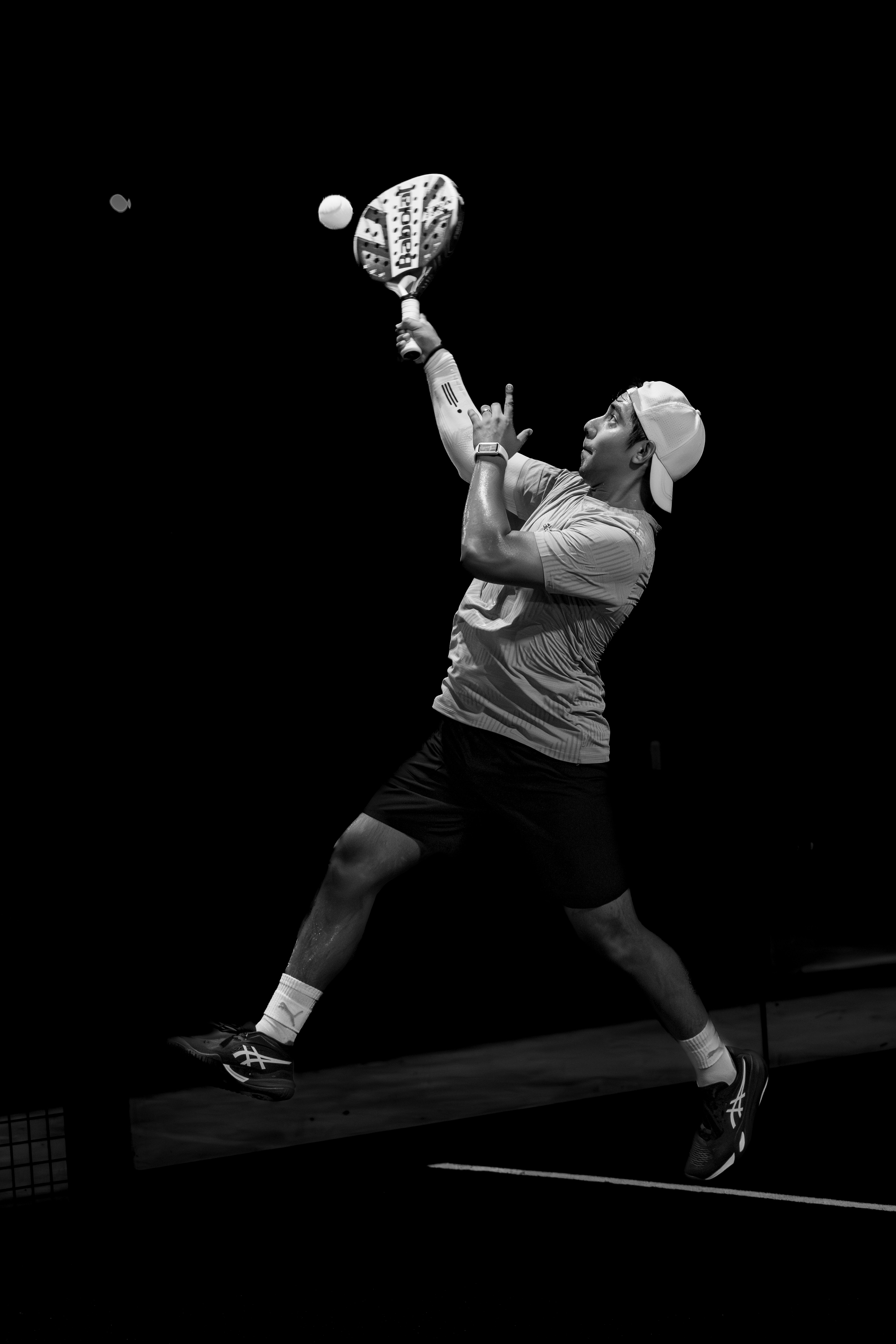 Padel player jumping for an overhead smash